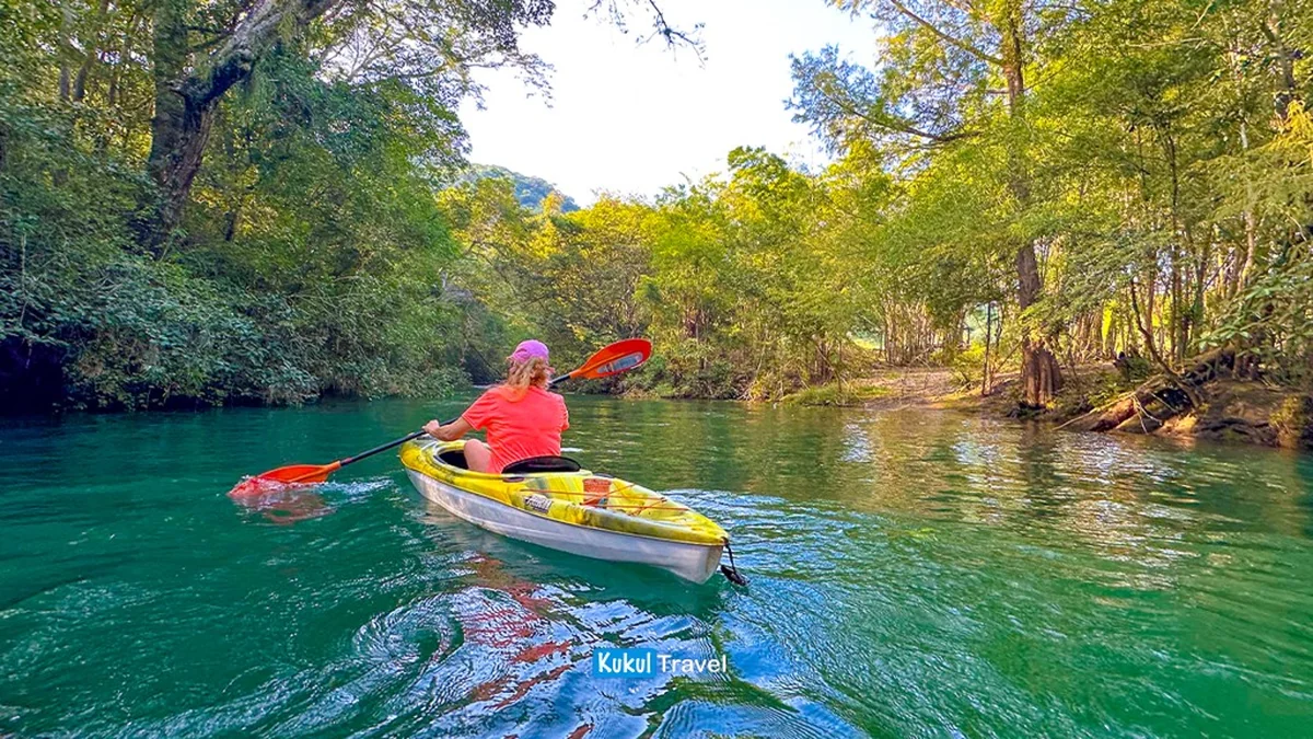 Persona en kayak sobre agua turquesa entre vegetación en la parte baja de "El Cielo"