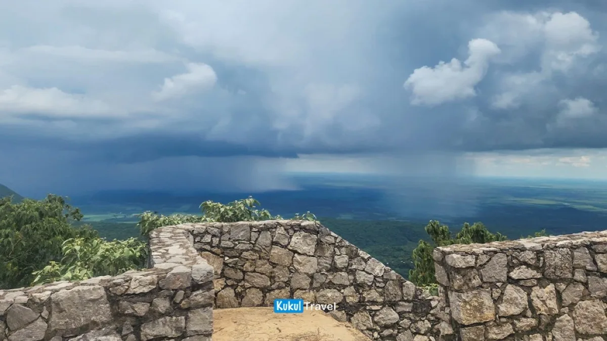 Mirador de piedra con valle verde y lluvia a la distancia en la Biosfera "El Cielo", referencia de clima y temporadas